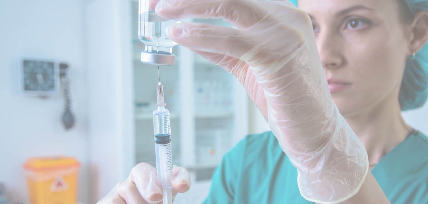 Медсестра набирает препарат из колбы